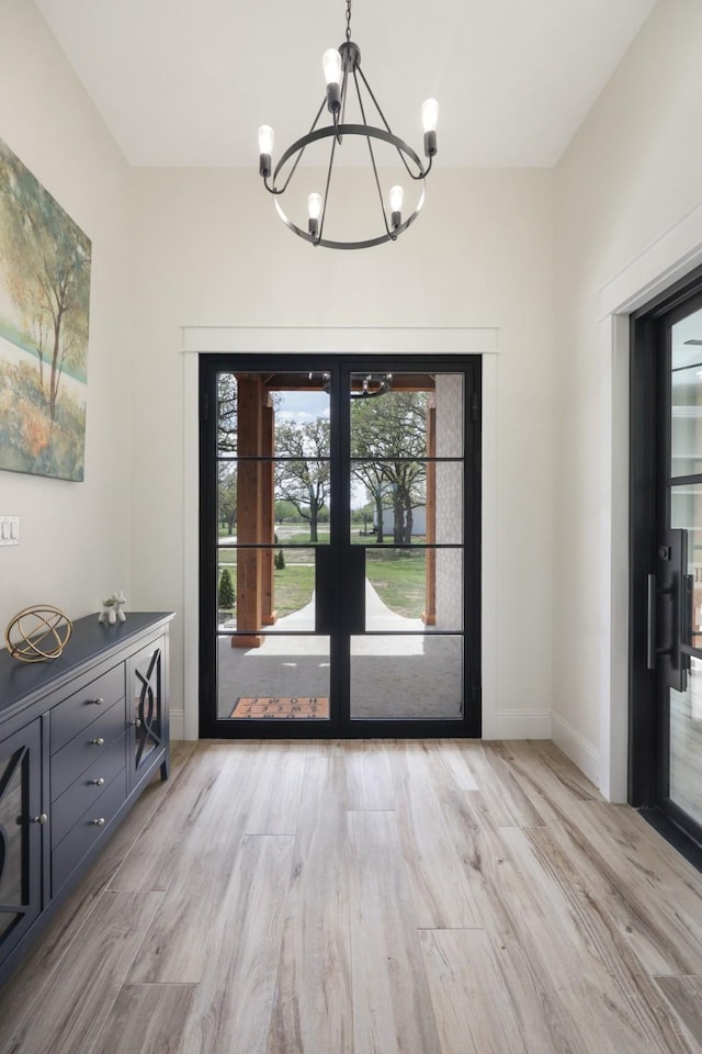 entryway featuring a chandelier, french doors, and light hardwood / wood-style floors