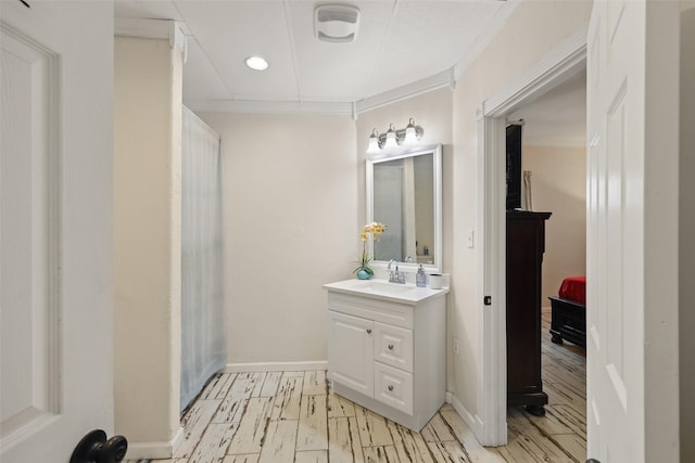 bathroom featuring wood-type flooring, vanity, and ornamental molding