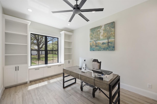 home office with light hardwood / wood-style floors and ceiling fan