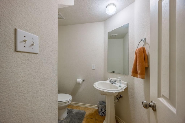 bathroom featuring toilet, tile patterned floors, and sink