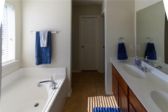 bathroom with vanity, a tub, and tile patterned floors