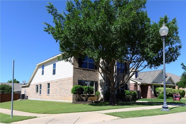 view of front of home with central AC and a front lawn