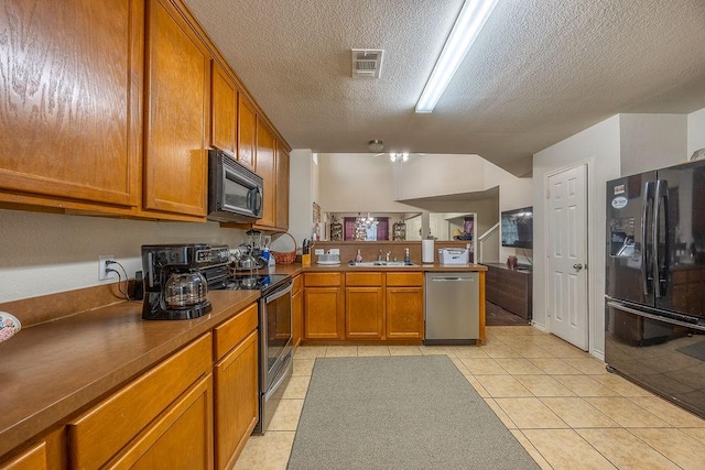 kitchen featuring kitchen peninsula, a textured ceiling, black appliances, light tile patterned flooring, and sink