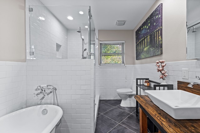 full bathroom featuring vanity, tile walls, plus walk in shower, tile patterned flooring, and toilet