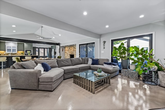 living room with a fireplace, ceiling fan, lofted ceiling, and sink