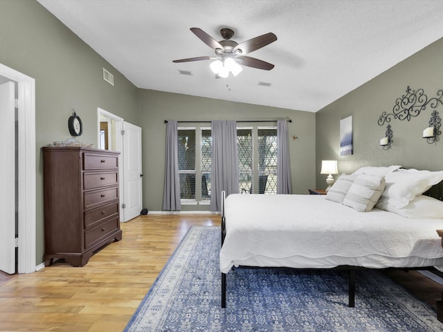 bedroom featuring lofted ceiling, ceiling fan, light hardwood / wood-style floors, a textured ceiling, and access to outside