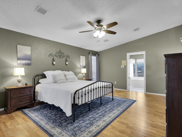 bedroom featuring light hardwood / wood-style flooring, multiple windows, and vaulted ceiling