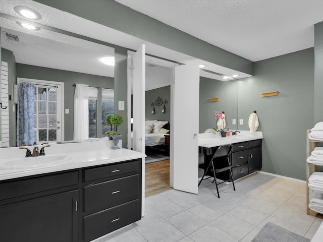 bathroom with vanity, tile patterned flooring, and a textured ceiling