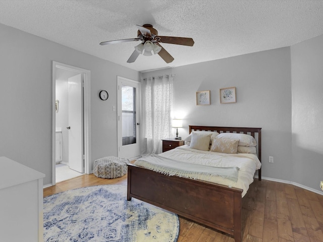 bedroom featuring hardwood / wood-style flooring, ceiling fan, connected bathroom, and a textured ceiling