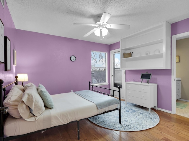 bedroom featuring ceiling fan, light hardwood / wood-style floors, and a textured ceiling