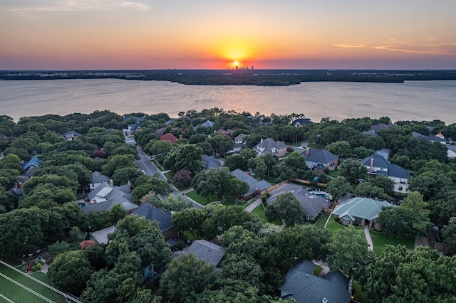 aerial view at dusk featuring a water view