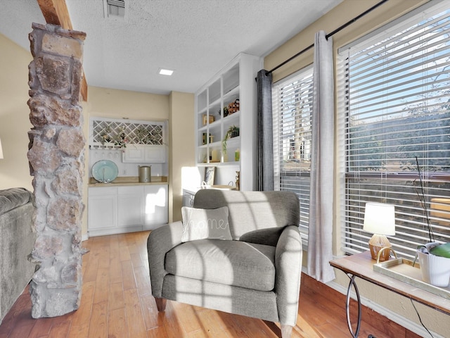 sitting room with a textured ceiling and light hardwood / wood-style floors