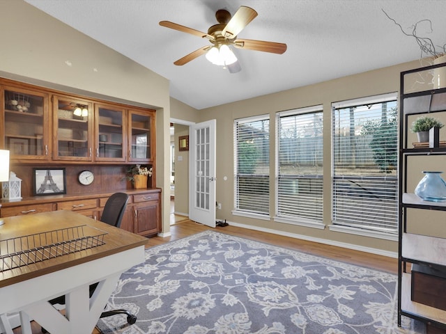 home office featuring ceiling fan, lofted ceiling, and light wood-type flooring