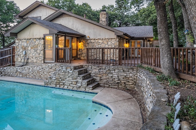 rear view of property with a fenced in pool