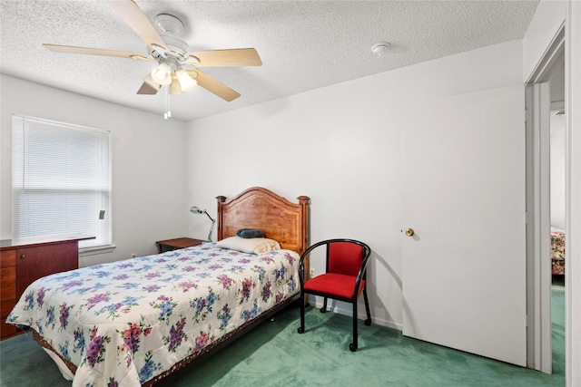 carpeted bedroom with ceiling fan and a textured ceiling