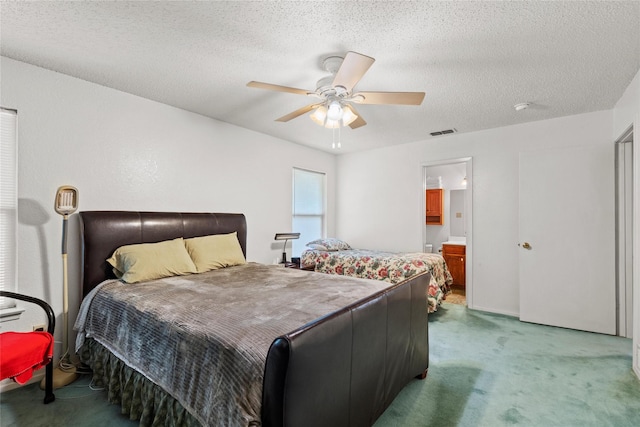 carpeted bedroom featuring a textured ceiling, ceiling fan, and ensuite bathroom