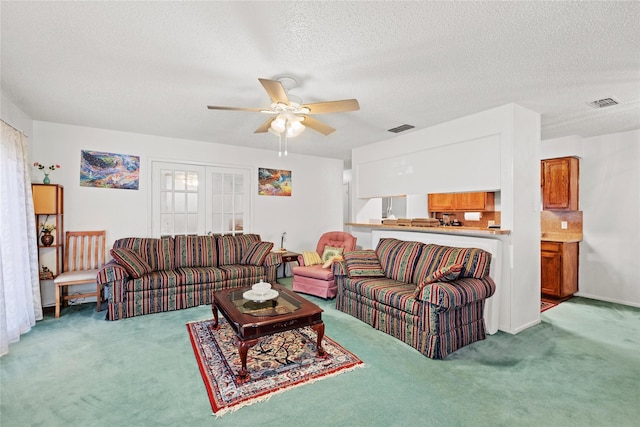 living room with carpet flooring, a textured ceiling, and ceiling fan