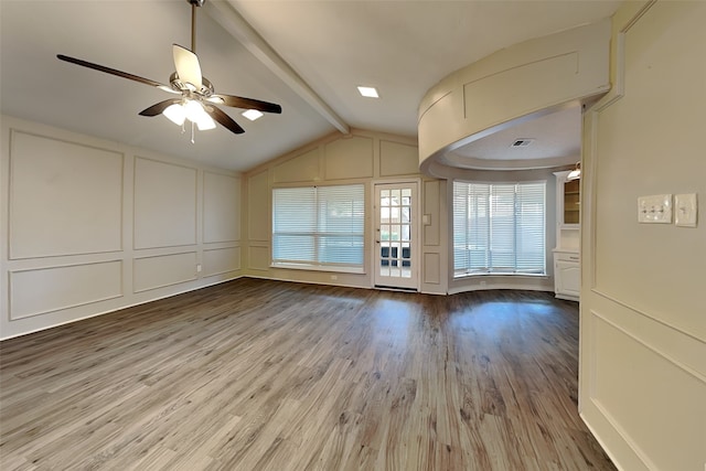 unfurnished living room featuring hardwood / wood-style floors, vaulted ceiling with beams, and ceiling fan