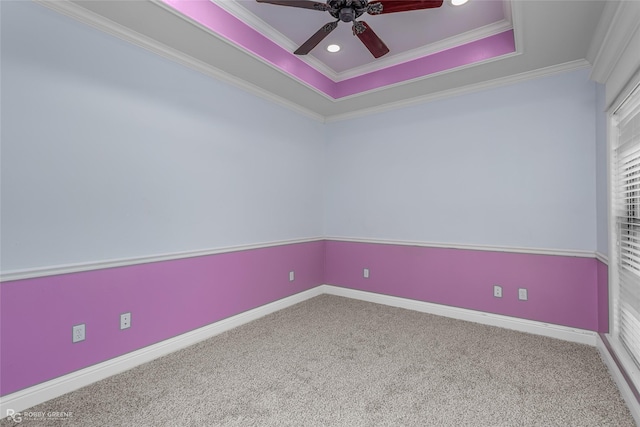 carpeted spare room with a tray ceiling, ceiling fan, and crown molding