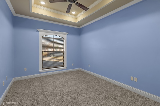 empty room featuring carpet floors, a raised ceiling, ceiling fan, and crown molding