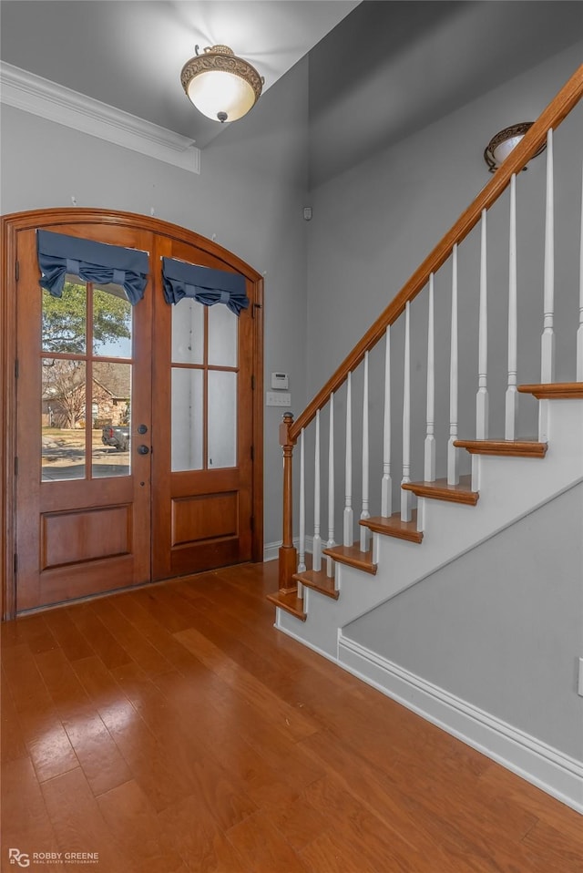 foyer featuring french doors, hardwood / wood-style flooring, and crown molding