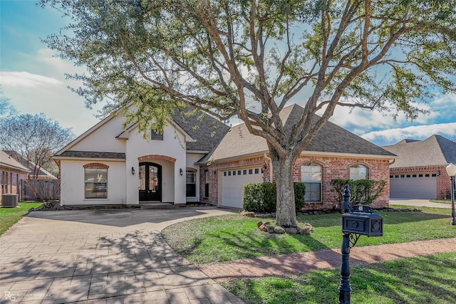 view of front of house with a front yard, french doors, and a garage