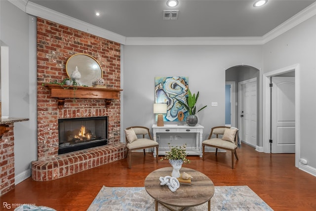 living room with a fireplace, wood-type flooring, and crown molding