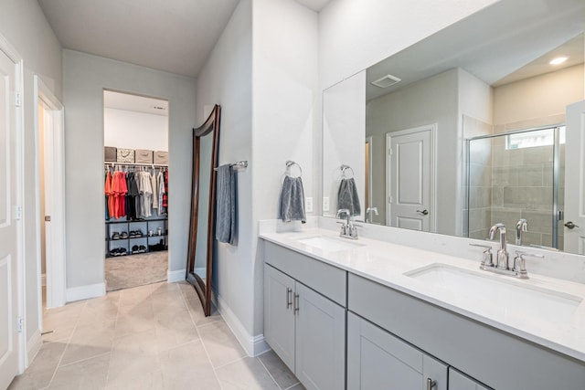 bathroom featuring tile patterned flooring, vanity, and walk in shower