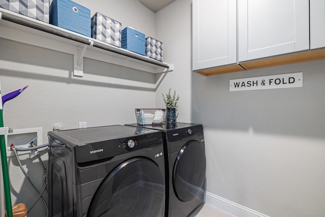 washroom featuring cabinets and washing machine and clothes dryer