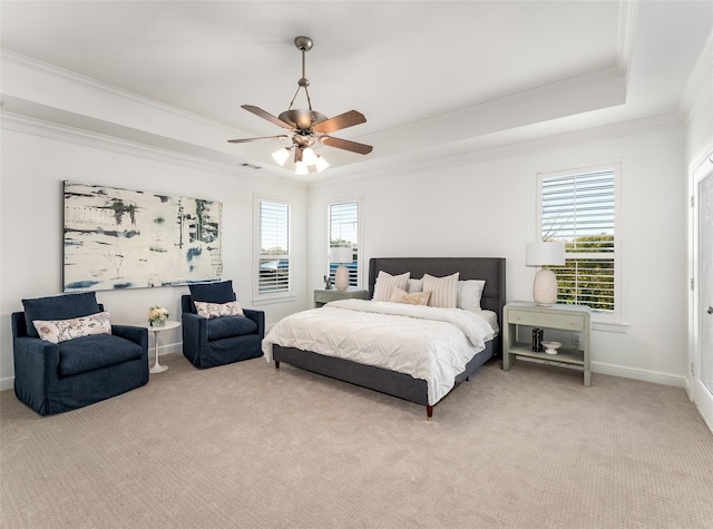 bedroom featuring a raised ceiling, multiple windows, ceiling fan, and light colored carpet