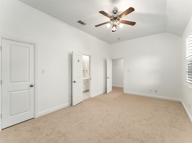 unfurnished bedroom with ensuite bath, ceiling fan, light colored carpet, and lofted ceiling