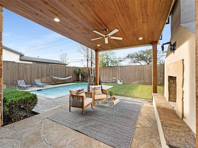 view of patio with ceiling fan and a fenced in pool