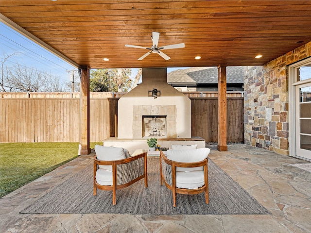 view of patio / terrace with an outdoor living space with a fireplace and ceiling fan