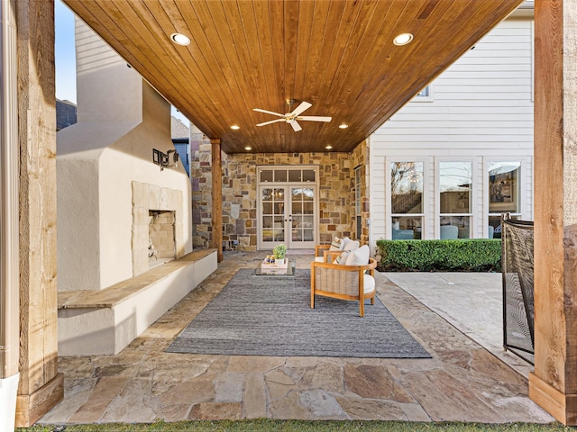 view of patio with an outdoor stone fireplace and ceiling fan