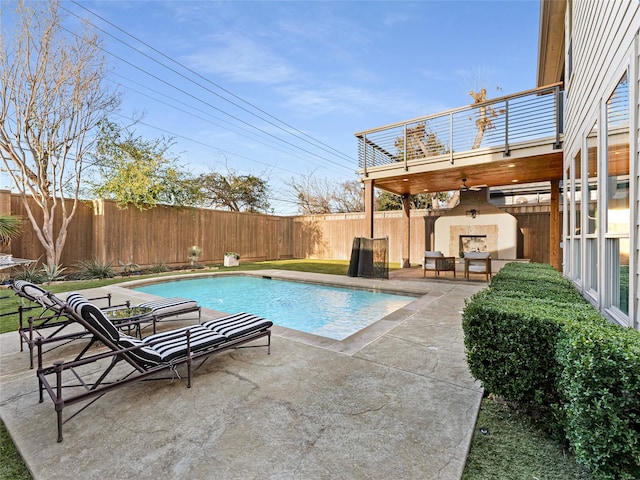 view of swimming pool with a patio and an outdoor fireplace