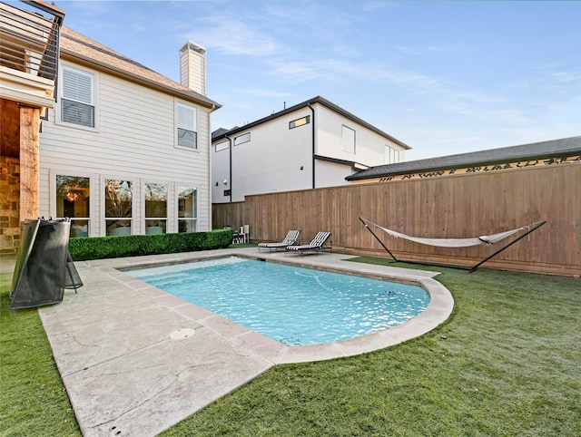 view of swimming pool with a patio area and a yard