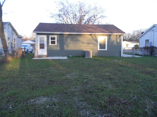 back of house featuring a lawn and central air condition unit