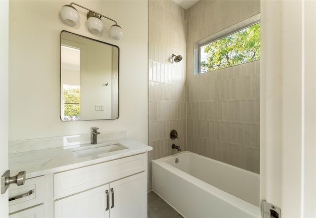 bathroom featuring vanity, tile patterned floors, and tiled shower / bath