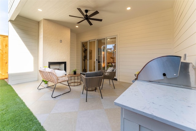 view of patio featuring ceiling fan, a fireplace, and grilling area