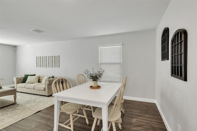 dining space with dark hardwood / wood-style flooring