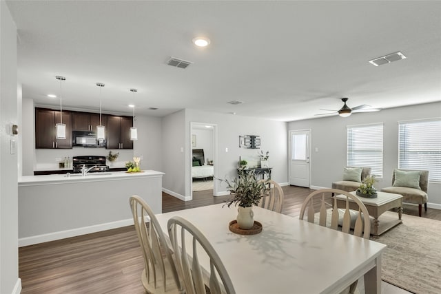 dining space featuring ceiling fan and dark wood-type flooring