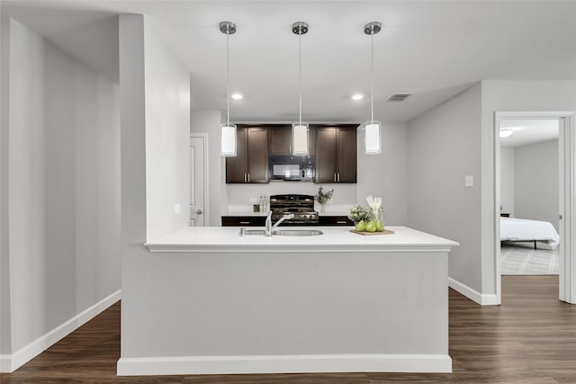 kitchen featuring sink, dark hardwood / wood-style flooring, pendant lighting, dark brown cabinets, and black appliances