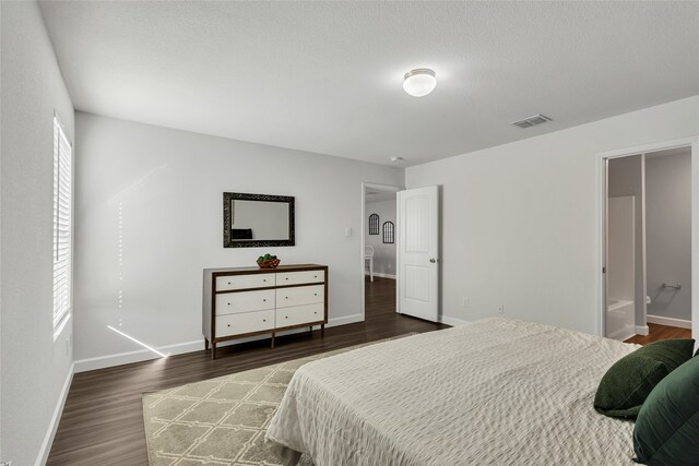 bedroom featuring dark hardwood / wood-style floors and connected bathroom