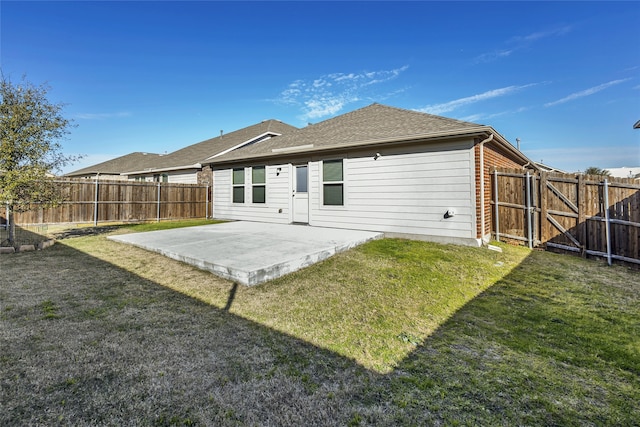 rear view of house featuring a patio area and a yard