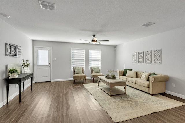 living room with a textured ceiling, hardwood / wood-style flooring, and ceiling fan