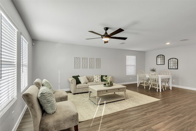 living room with dark hardwood / wood-style flooring and ceiling fan