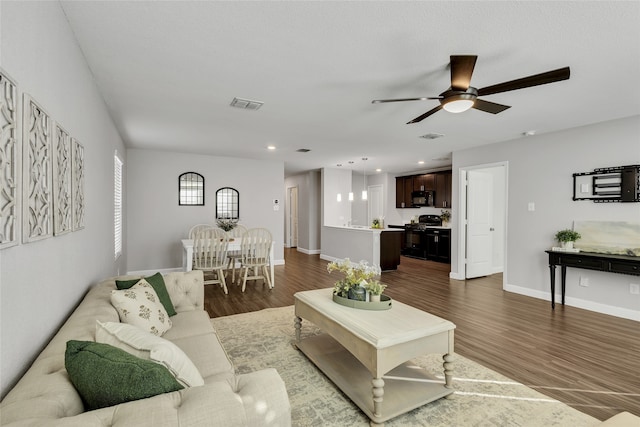 living room featuring ceiling fan and hardwood / wood-style floors