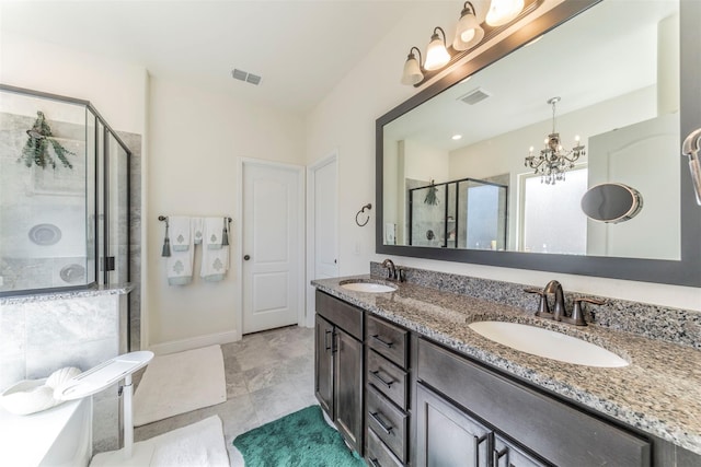 bathroom featuring a notable chandelier, a shower with shower door, and vanity