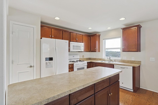 kitchen featuring sink, white appliances, and light wood-type flooring