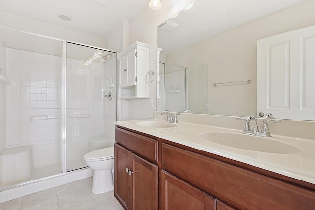 bathroom featuring tile patterned floors, vanity, toilet, and a shower with door